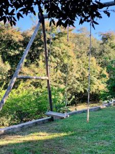 a swing in a park with trees in the background at F2 avec jacuzzi, pétanque, à 3 min mer, dans grande propriété in Porticcio