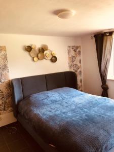 1 dormitorio con 1 cama con manta azul en Gîte la mosane en Profondeville