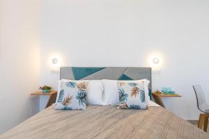 a bedroom with a bed with blue and white pillows at Baia Flegrea Meublè in Bacoli