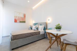 a small bedroom with a bed and a table at Baia Flegrea Meublè in Bacoli