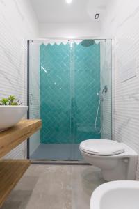 a bathroom with a toilet and a glass shower at Baia Flegrea Meublè in Bacoli