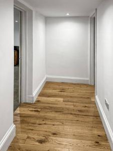 an empty room with wooden floors and white walls at Cosy 1-BDR w/ free parking in central Reading in Reading