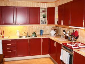 AlstadにあるThree-Bedroom Holiday home in Leknes 1のキッチン(赤いキャビネット、コンロ付)