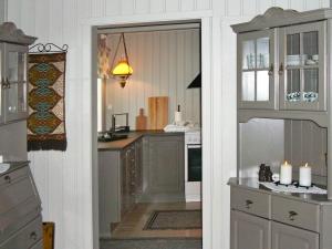 una cocina con una puerta que da a una cocina con encimera en Four-Bedroom Holiday home in Eide, en Eide