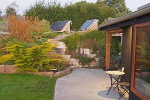 a patio with a table and some plants and solar panels at Kotare BandB in Geraldine