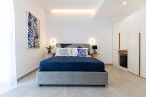 a bedroom with a blue bed in a white room at Baia Flegrea Meublè in Bacoli