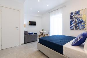 a bedroom with a bed and a living room at Baia Flegrea Meublè in Bacoli