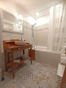 a bathroom with a sink and a tub with a mirror at Gite avec piscine "La maison de Valentine" en Provence in Le Plan