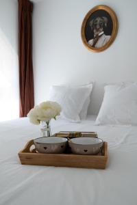 a tray with two bowls and a vase of flowers on a bed at LITTLE MAMA including free parking at 100 meters in Colmar