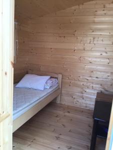 a small room with a bed in a wooden wall at Koli caravan cottages in Kolinkylä