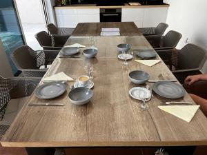 a wooden table with plates and wine glasses on it at Villa Birk in Barbat na Rabu