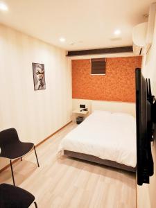 さいたま市にあるHotel mond omiyaのベッドルーム(ベッド1台、テレビ、椅子付)