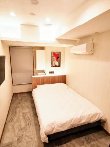 ein kleines Zimmer mit einem Bett darin in der Unterkunft Hotel mond omiya in Saitama
