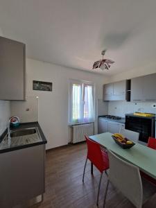 a kitchen with a table and red chairs in a room at VETULONIA ROMANTICA in Vetulonia