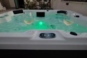 two glasses of wine in a hot tub at Morfeo Charming Rooms & Relax in Avola