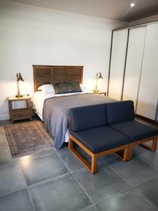 1 dormitorio con 1 cama y 1 sofá azul en 10 Jock Meiring Guesthouse unit 1, en Bloemfontein