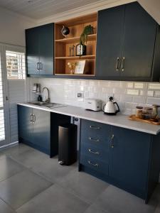 una cocina con armarios azules y fregadero en 10 Jock Meiring Guesthouse unit 1 en Bloemfontein