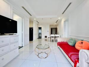 sala de estar con sofá rojo y TV de pantalla plana en Vinhomes Central Park -Luxury Christine Apartment, en Ho Chi Minh