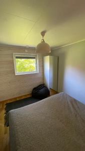 een slaapkamer met een groot bed en een raam bij Floda, Minihus på 62m2 för plats för 4 vuxna och 2 barn in Floda