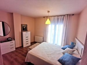 sypialnia z łóżkiem, komodą i lustrem w obiekcie Riaza Vacacional - Apartamento en el centro w mieście Riaza