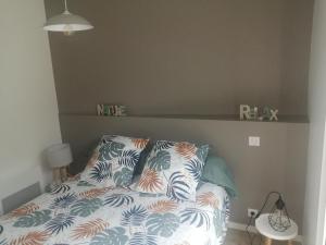 - une chambre avec un lit et des oreillers dans l'établissement Petite maison charmante en baie de Saint-Brieuc entre Paimpol et Erquy Wifi et parking gratuit, à Ploufragan