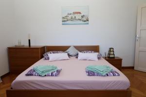 ein Schlafzimmer mit einem Bett mit zwei Kissen darauf in der Unterkunft Apartman DAJANA in Supetar