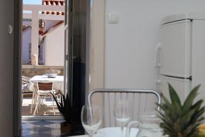 a balcony with a table and chairs and wine glasses at Apartman DAJANA in Supetar