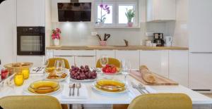 a kitchen with a table with plates of food on it at Cvita & Gabi - kuća za odmor in Privlaka