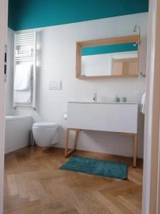 een badkamer met een wastafel, een toilet en een spiegel bij Letizia Apartment in Crotone +17 foto's