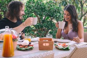 un hombre y una mujer sentados en una mesa comiendo comida en B&B Maria Grazia, en Vico Equense