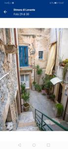 a picture of an alley with a building with plants at Lungomare Elio Vittorini in Siracusa