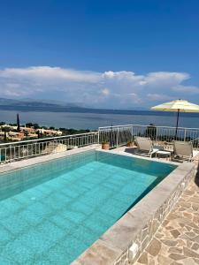 basen z krzesłami i parasolem oraz ocean w obiekcie Villa Alemar House with Private pool and Spectacular sea views just 150m to the beach w mieście Barbati