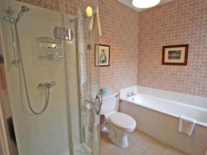 a bathroom with a toilet and a tub and a shower at Viewfield House in Portree