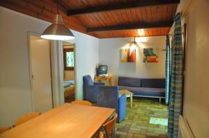 a living room with a table and a dining room at Village de Vacances d'Oignies in Oignies