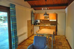 a kitchen with a table and chairs in a room at Village de Vacances d'Oignies in Oignies-en-Thierache