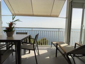 a balcony with a table and chairs and a view of the ocean at OverTheSea - PUEBLECITO Apartment in Roses