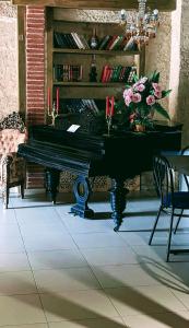 a black piano sitting in a room with a table at Hotel Kalanga in Tbilisi City