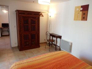 1 dormitorio con cama, mesa y armario en Gîte L'Orangeraie - 2 Adultes - 2 enfants, en Elne