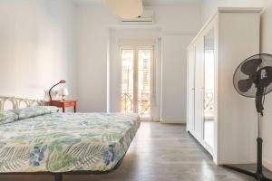 a white bedroom with a bed and a fan at 120 sqm Loft-style Apartment Beach Royal Marina in Valencia