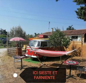 a boat is parked next to a table and a sign at MES NUITS VINTAGE EN COMBI in Robion en Luberon