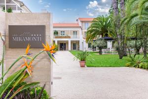 a building with a sign in front of a yard at Resort Miramonti in Forte dei Marmi