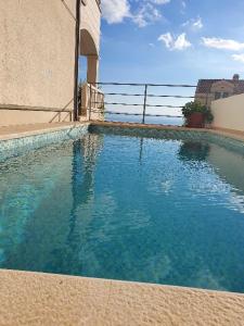 a swimming pool with blue water in front of a building at Apartment J&J in Makarska