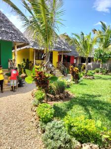 a group of people walking towards a house at Kendwa Carletto Style in Kendwa