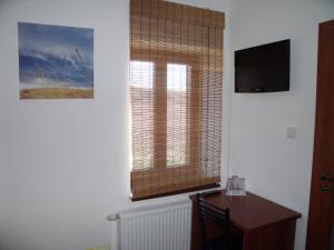 Cette chambre dispose d'un bureau et d'une fenêtre avec une table. dans l'établissement Penzion Farmer Kapušany, à Kapušany