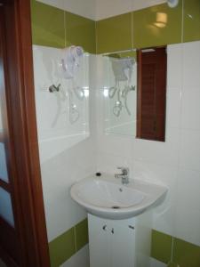 a bathroom with a sink and a mirror at Penzion Farmer Kapušany in Kapušany