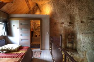 a bedroom with a bed and a stone wall at TROGLODYTE LOFT 2 in Thoré-la-Rochette
