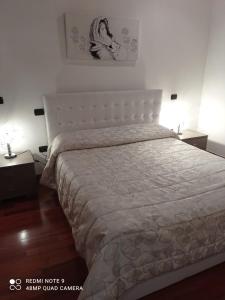 een slaapkamer met een groot bed met een witte sprei bij Dimora di Mara in Santeramo in Colle