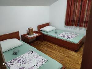 a small room with two beds and a table at Apartman JURE in Supetar