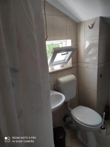 a small bathroom with a toilet and a window at Apartman JURE in Supetar