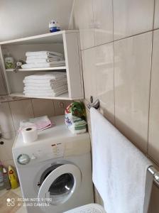 a bathroom with a washing machine and a towel at Apartman JURE in Supetar